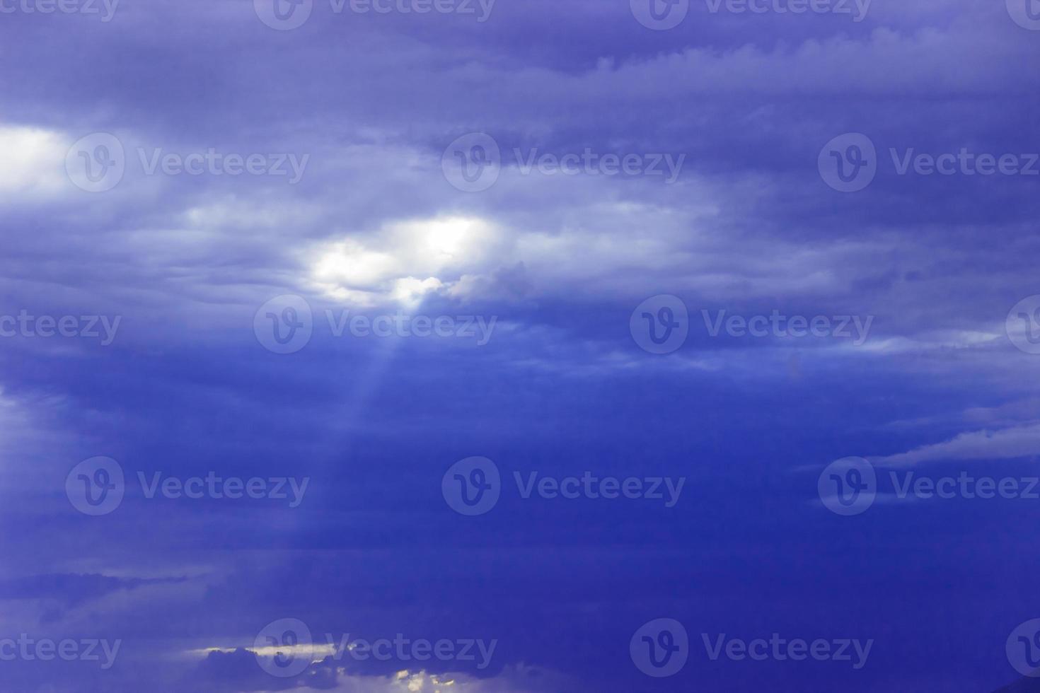 a través de las nubes sobre el mar se abre paso un rayo de sol foto