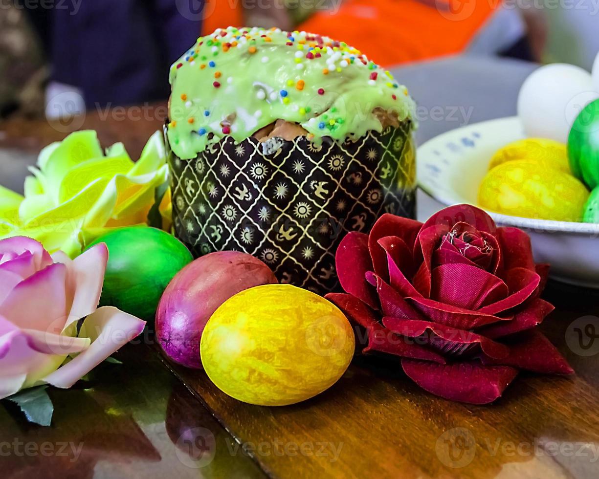 pasteles dulces de pascua con huevos coloridos en la mesa en la habitación foto