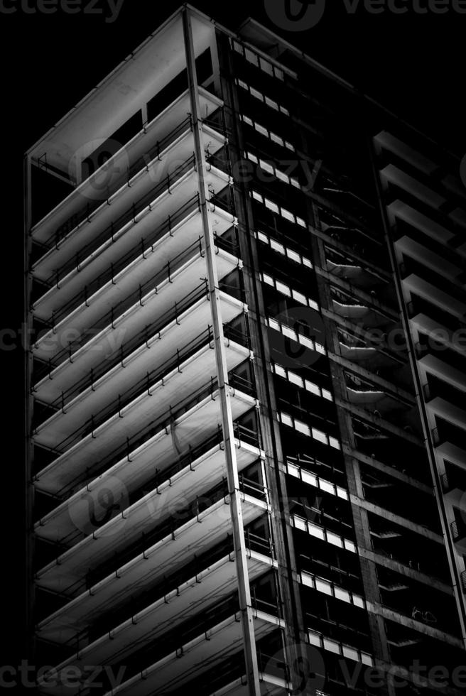 Black and white image of an unfinished multistory building in a low key. Unfinished building view at night. photo