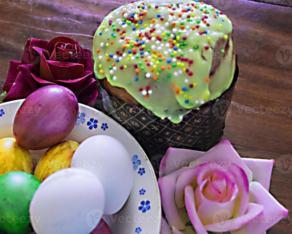 Sweet Easter cakes with colorful eggs on table in room photo
