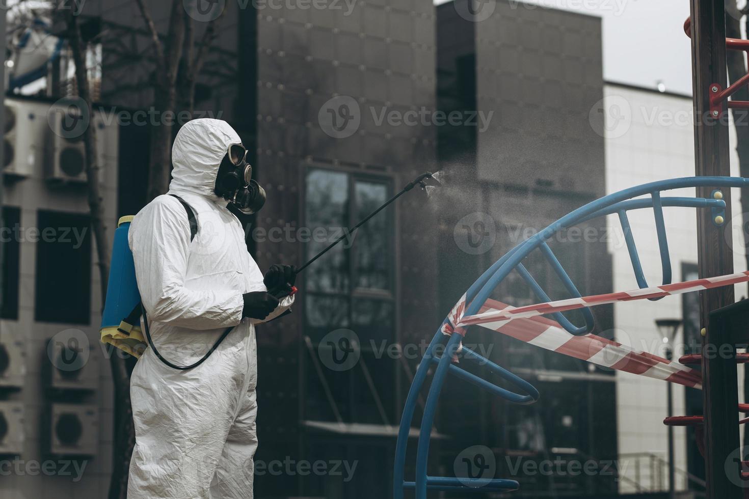 Cleaning and Disinfection on the playground in the sity complex amid the coronavirus epidemic Teams for disinfection efforts Infection prevention and control of epidemic Protective suit and mask photo