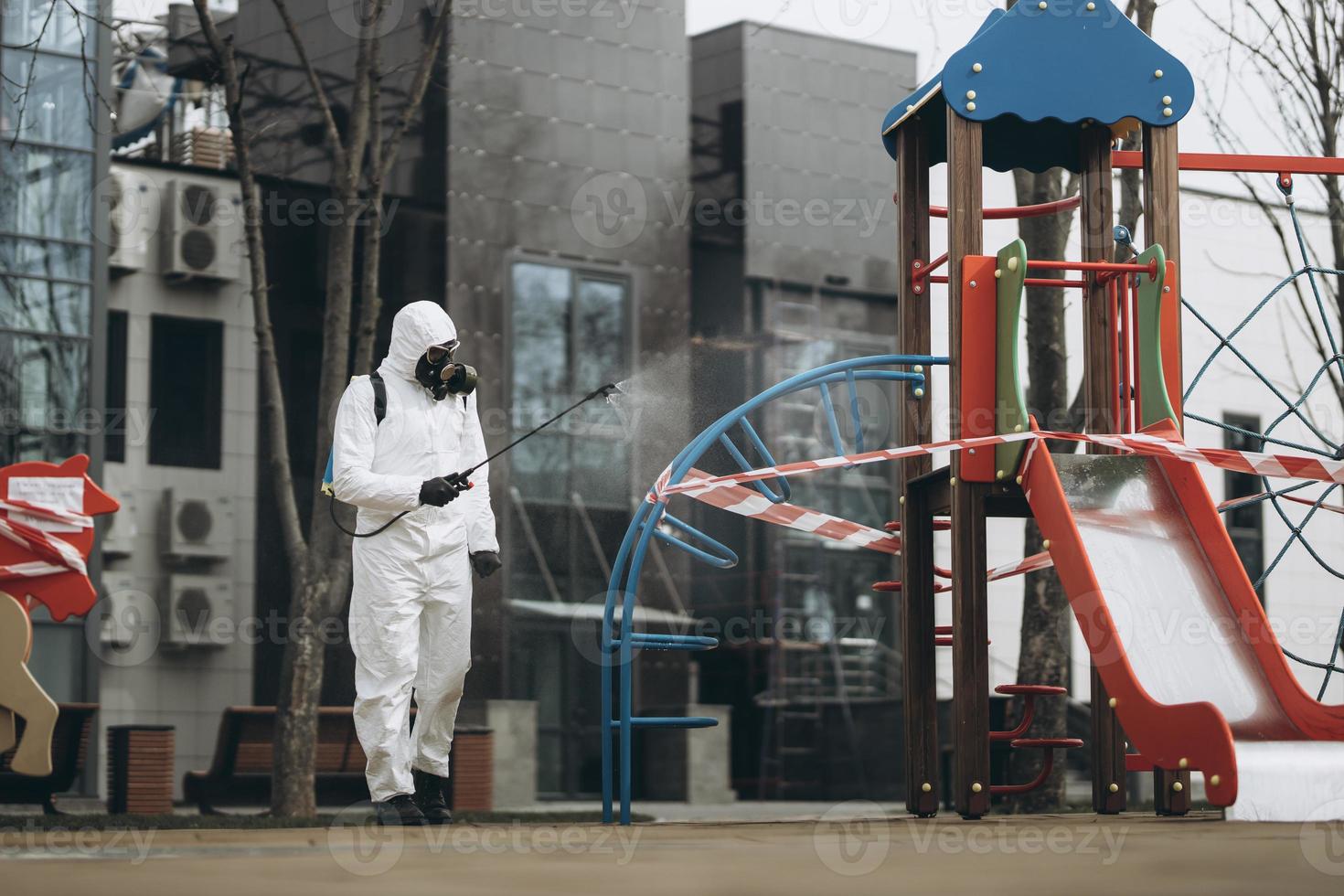 Cleaning and Disinfection on the playground in the sity complex amid the coronavirus epidemic Teams for disinfection efforts Infection prevention and control of epidemic Protective suit and mask photo