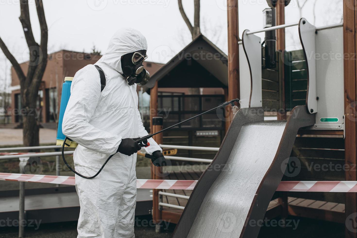 Cleaning and Disinfection on the playground in the sity complex amid the coronavirus epidemic Teams for disinfection efforts Infection prevention and control of epidemic Protective suit and mask photo
