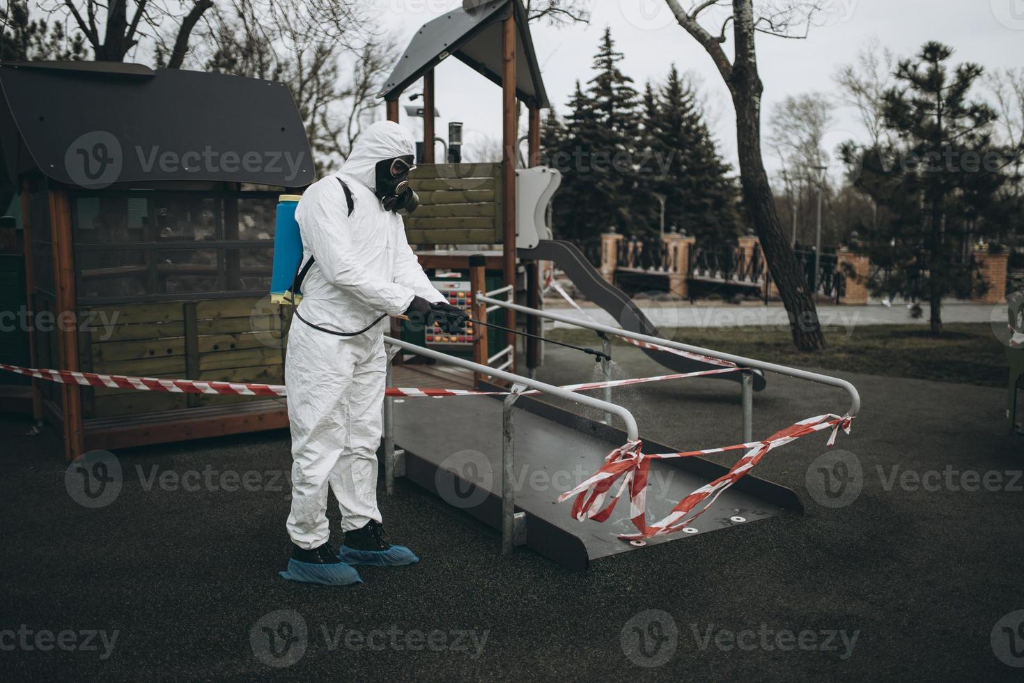 Cleaning and Disinfection on the playground in the sity complex amid the coronavirus epidemic Teams for disinfection efforts Infection prevention and control of epidemic Protective suit and mask photo