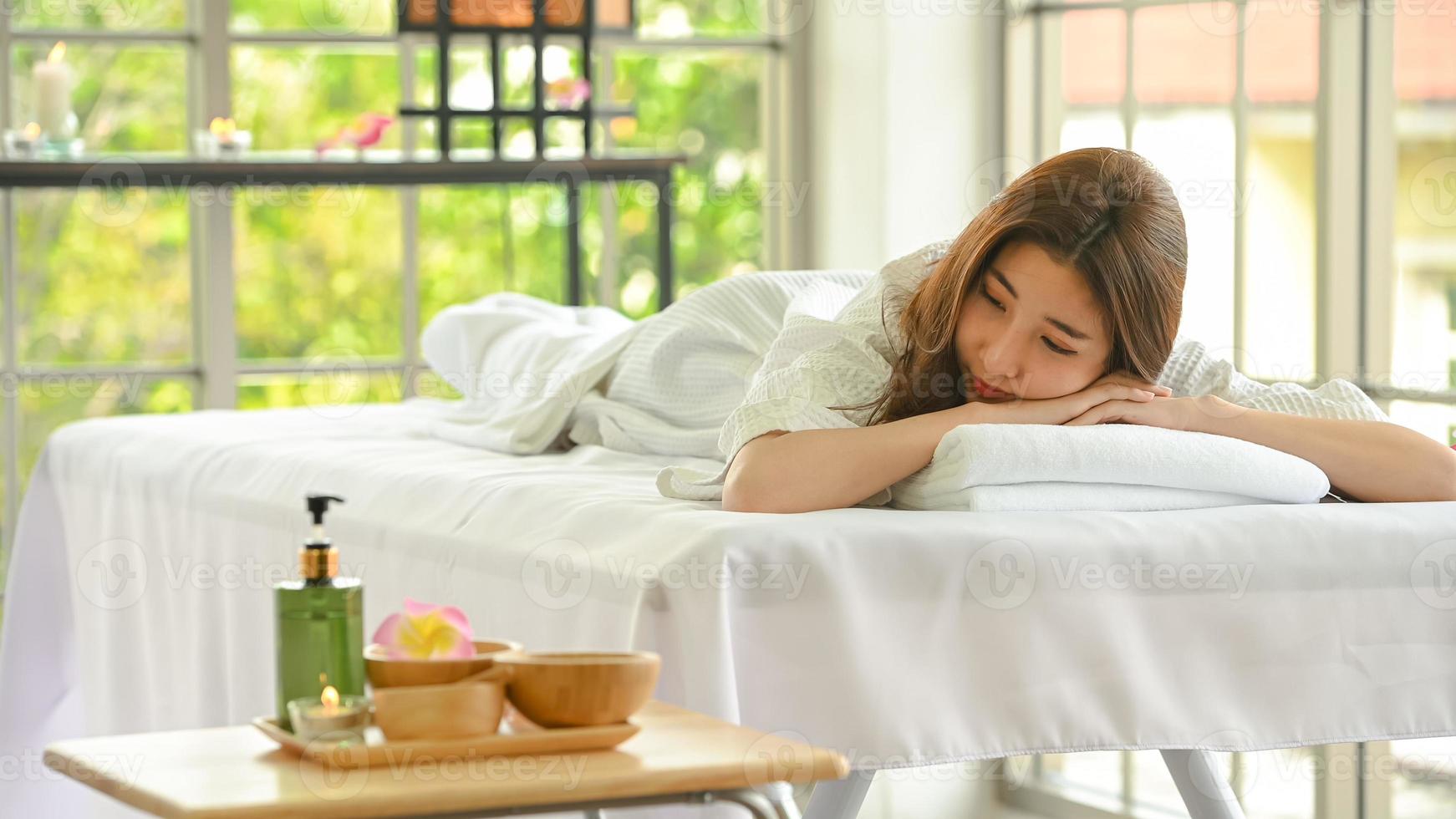 Portrait of young beautiful asian woman enjoys massage in a luxury spa resort photo