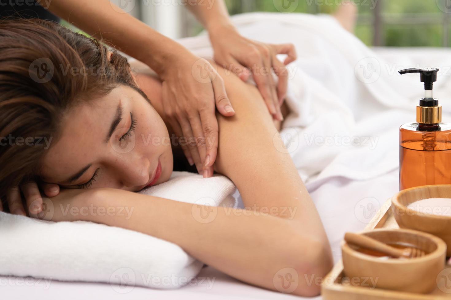 Portrait of young beautiful asian woman enjoys massage in a luxury spa resort photo