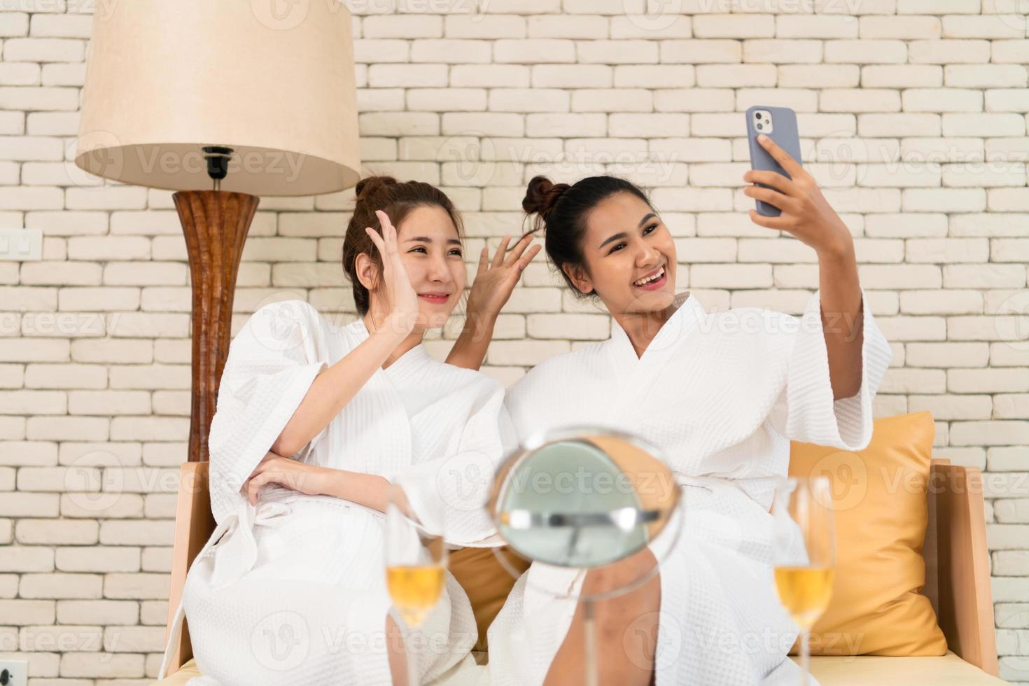 Two Asian female friends chat while waiting in the spa reception area photo