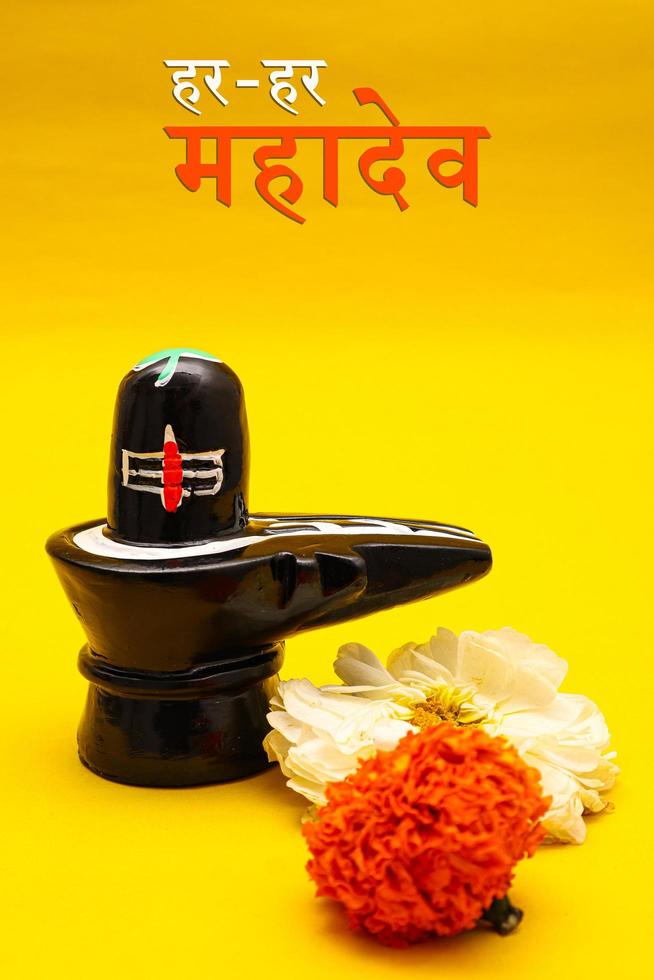 Shiva Linga decorated with flowers on yellow background. photo