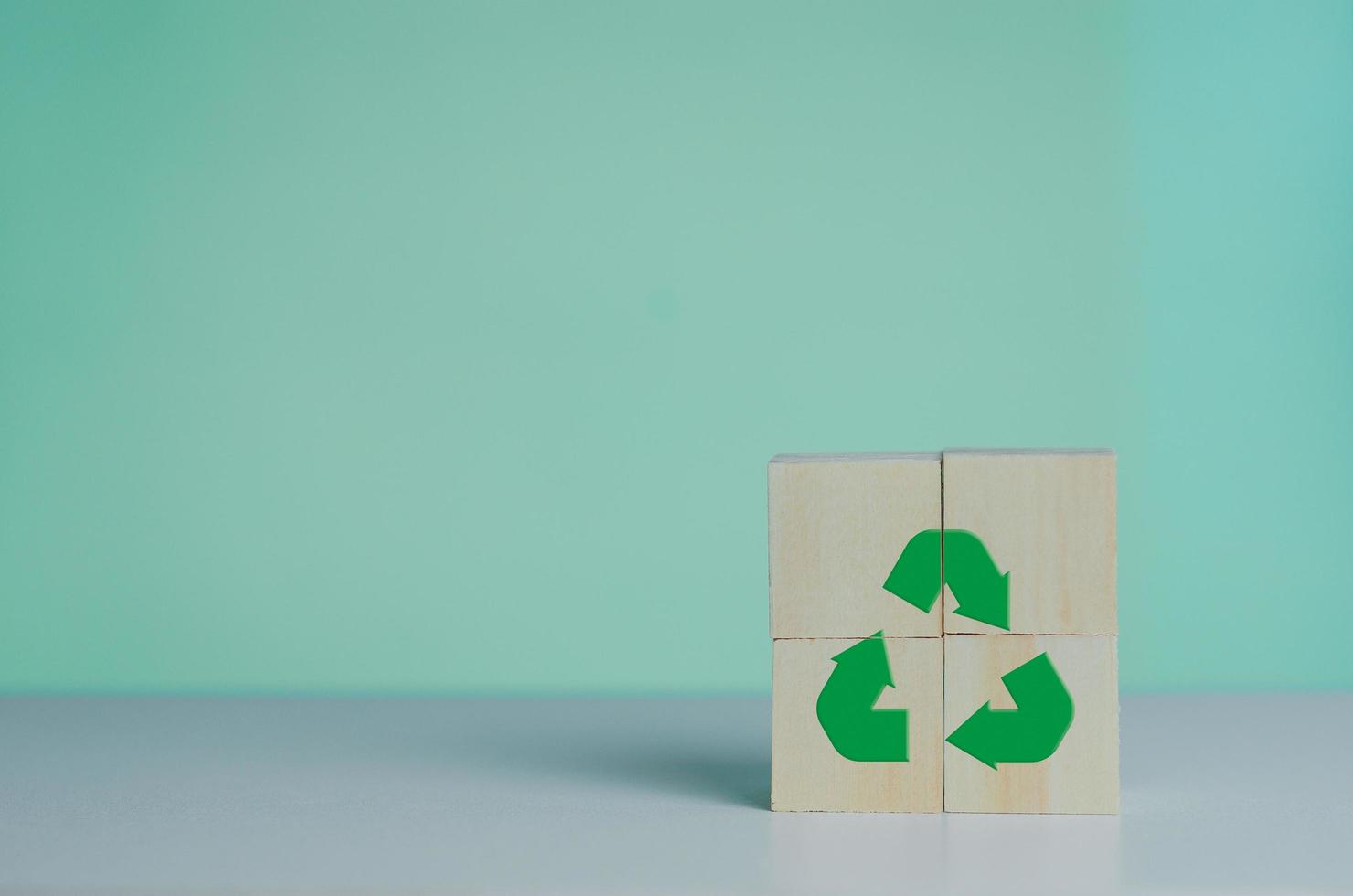 cubo de madera con icono de reciclaje y verde industrial. concepto de negocio y desarrollo ecológico en segundo plano. foto