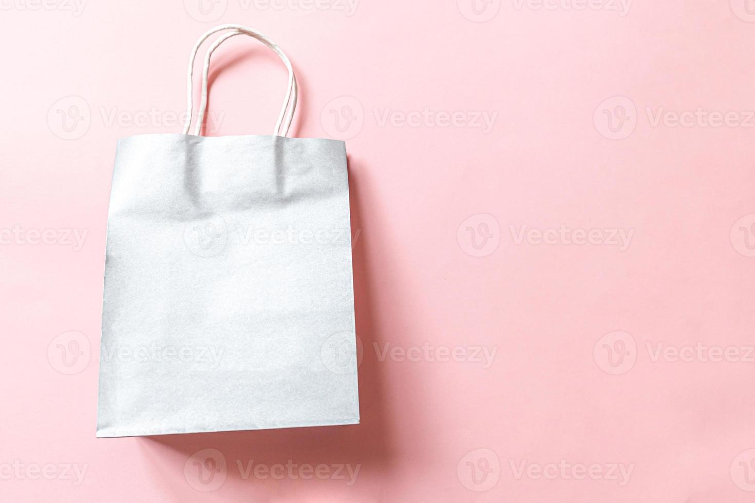 Simply minimal design shopping bag isolated on pink pastel background. Online or mall shopping shopaholic concept. Black friday Christmas season sale. Flat lay top view copy space, mock up photo