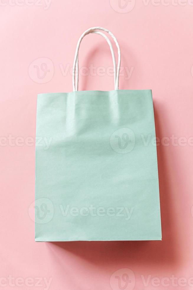 Simply minimal design shopping bag isolated on pink pastel background. Online or mall shopping shopaholic concept. Black friday Christmas season sale. Flat lay top view copy space, mock up photo