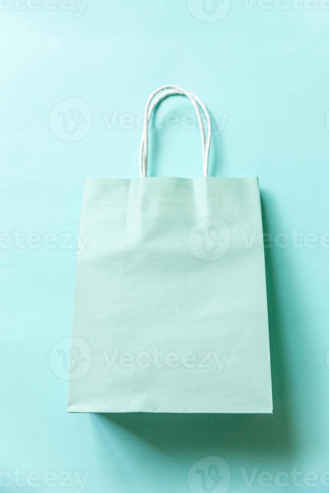 Simply minimal design shopping bag isolated on blue pastel background. Online or mall shopping shopaholic concept. Black friday Christmas season sale. Flat lay top view copy space, mock up photo