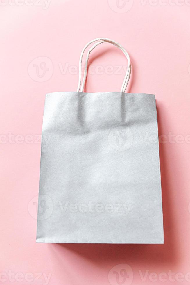 Simply minimal design shopping bag isolated on pink pastel background. Online or mall shopping shopaholic concept. Black friday Christmas season sale. Flat lay top view copy space, mock up photo