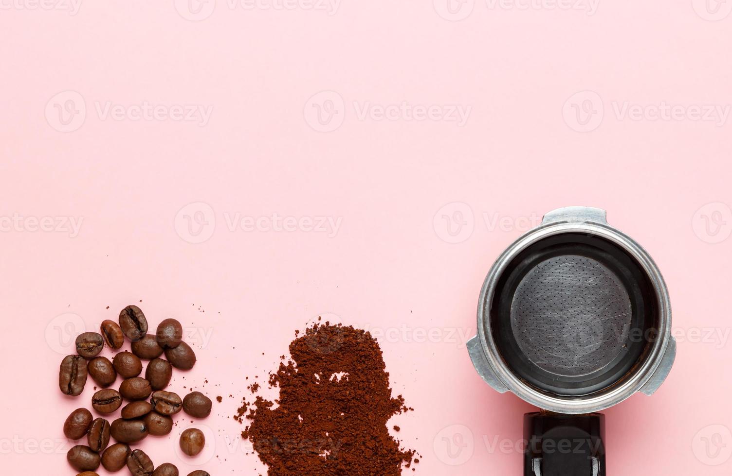 Detail of espresso machine filter holder, ground coffee and coffee beans on pink background. Space for text. photo