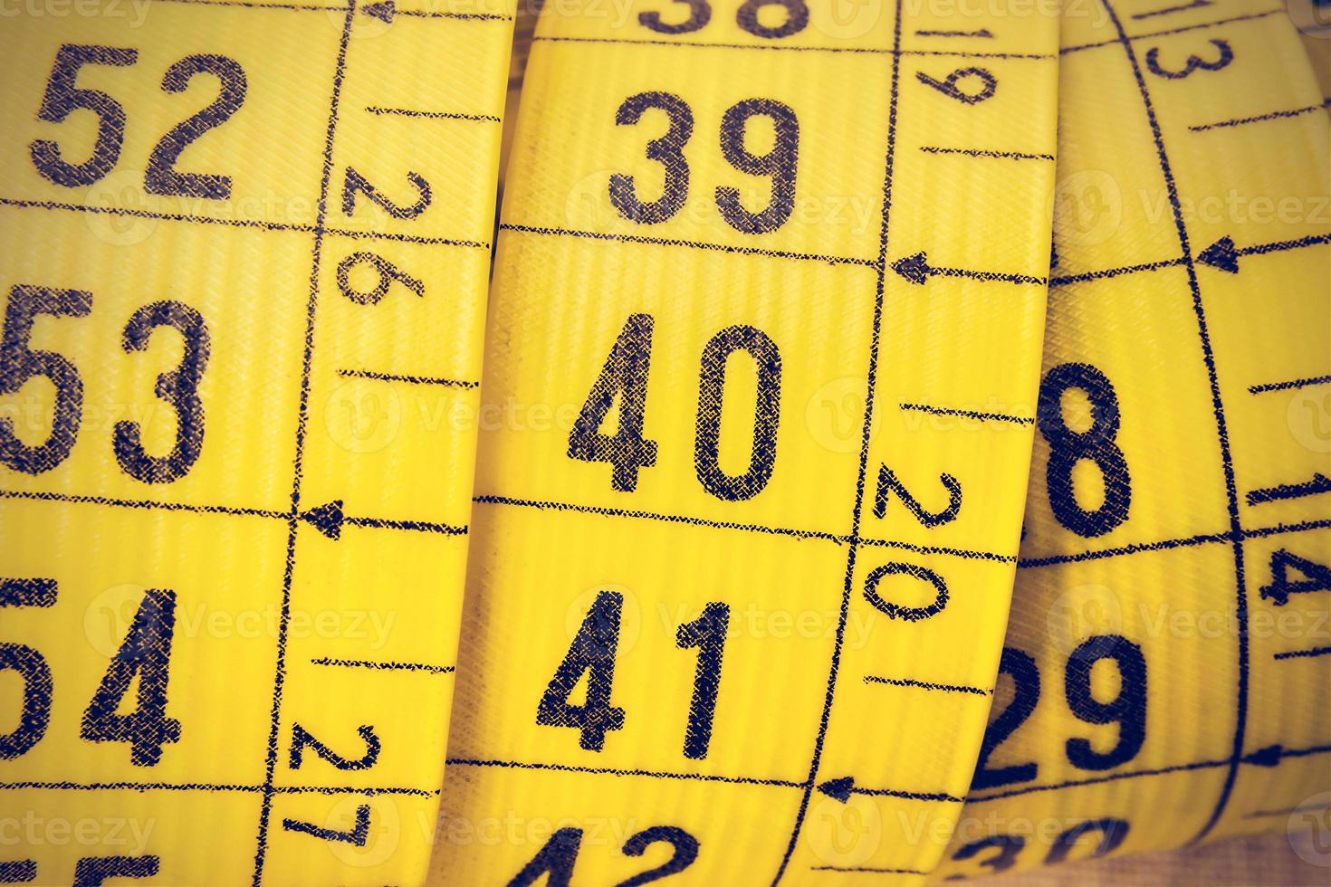 Yellow tailor measuring tape macro in a retro vintage style. Horizontal image. photo