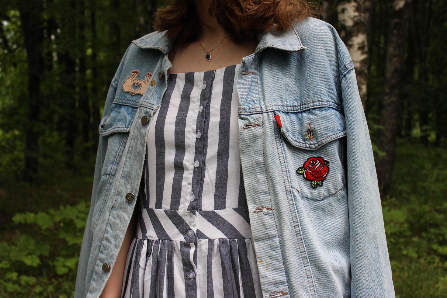 Young girl in jeans jacket and dress in the forest photo