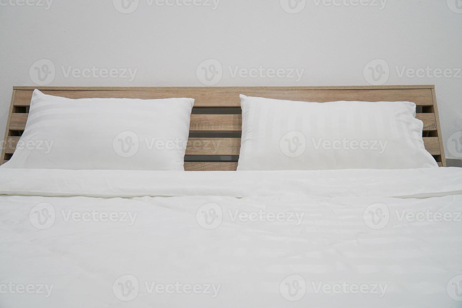 almohada blanca en la decoración de la cama en el interior del dormitorio foto