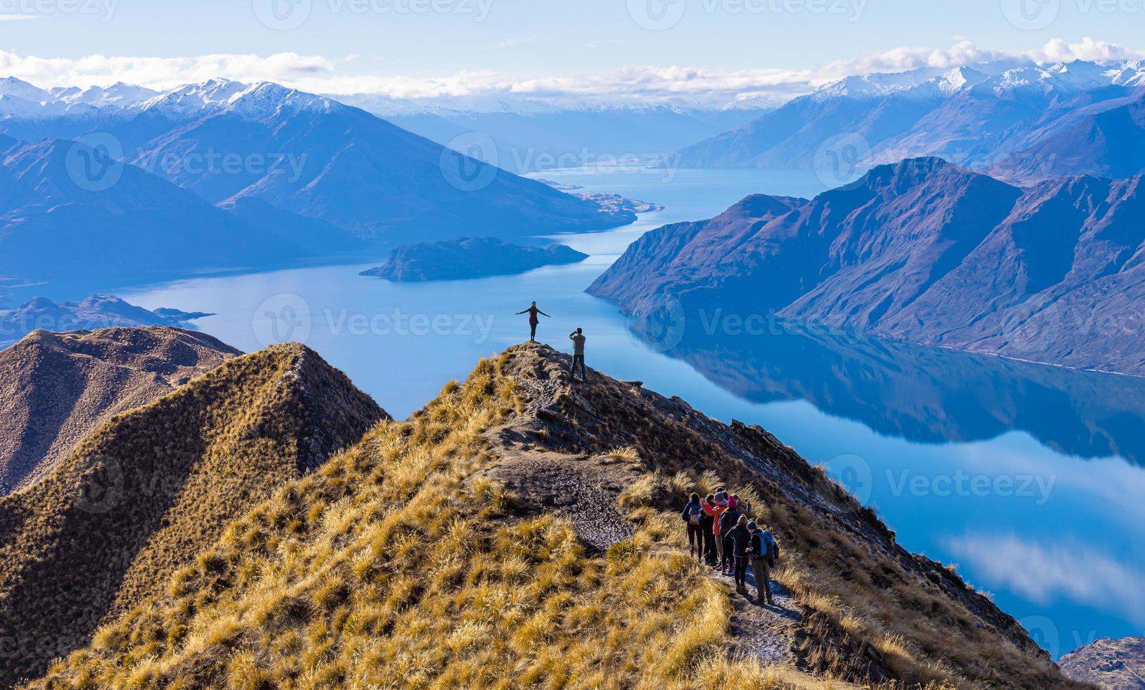 turistas asiáticos tomando fotos en el lago wanaka de roy's peak, nueva zelanda