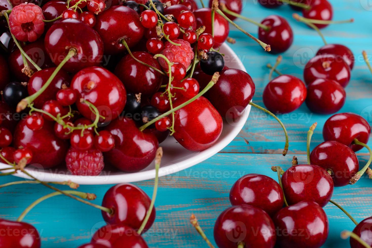 Close up of pile of ripe cherries with stalks and leaves photo