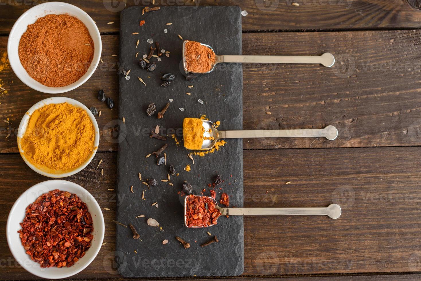 Spices and herbs on old kitchen table. Food and cuisine ingredients photo