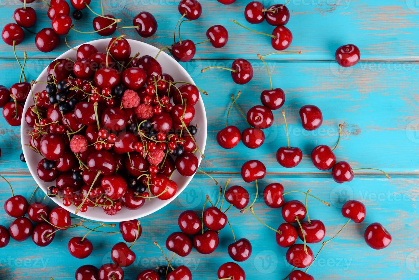 Close up of pile of ripe cherries with stalks and leaves photo