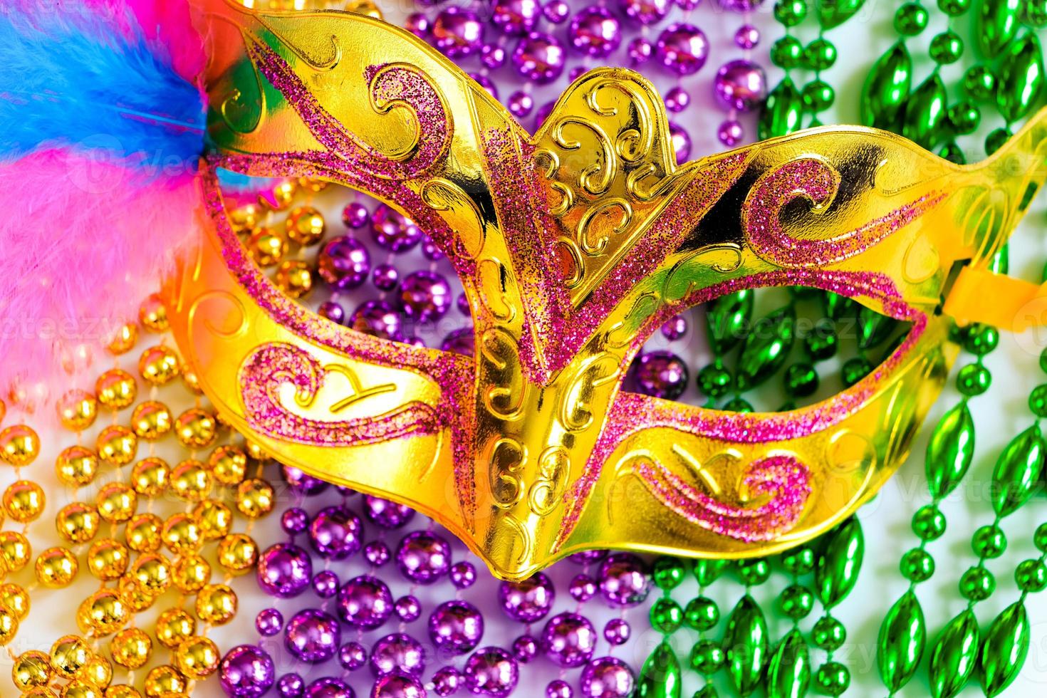 Golden carnival mask and colorful beads. photo