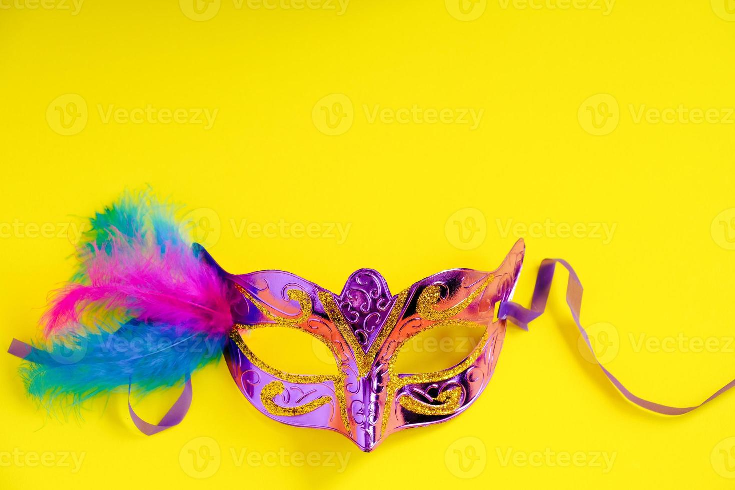 Carnival mask on yellow background. photo