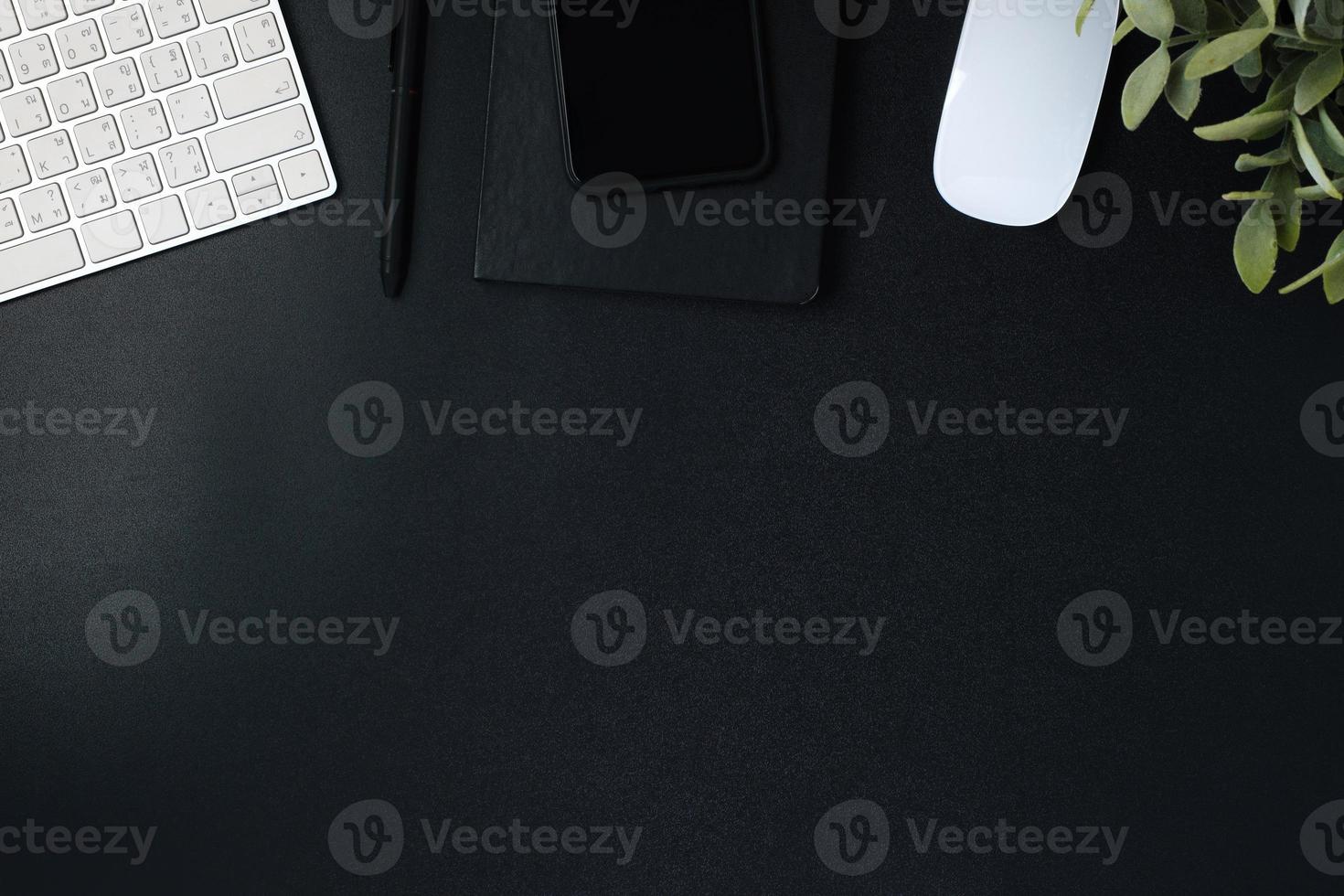 top view working desk with keyboard mouse and notebook on black table background photo