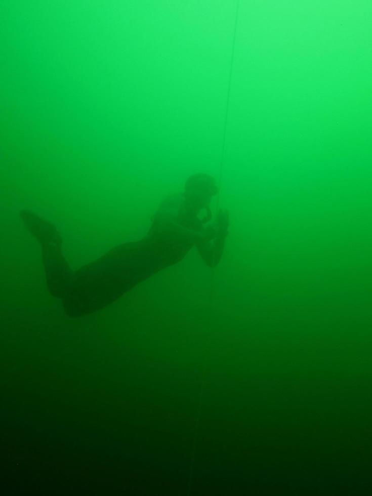 free diving or apnea diving submerged in lake in the summer photo