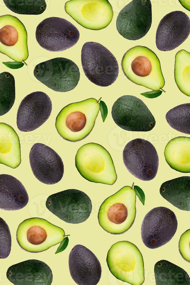 Slices and half of avocado on a yellow wallpaper background. photo