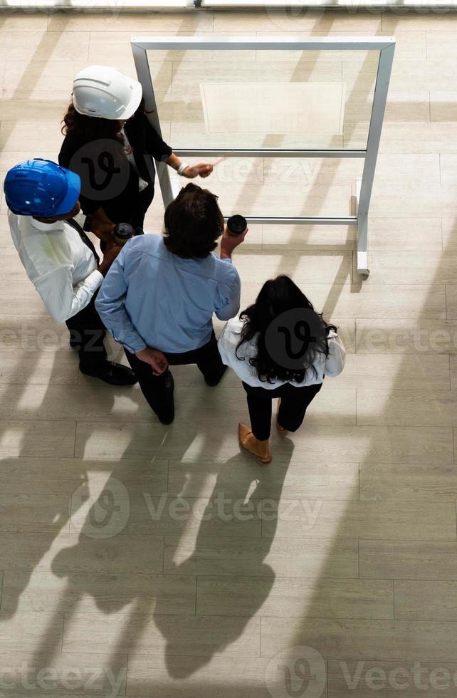 View From Above of Architect and Engineer Edit Blueprint Together in Meeting photo