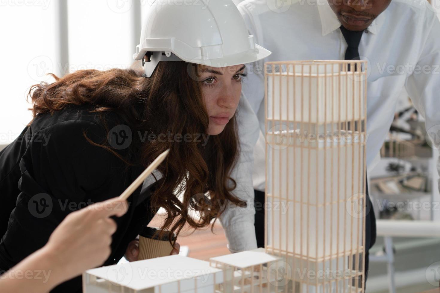 Young Engineer Looking at Building Model with Colleagues photo