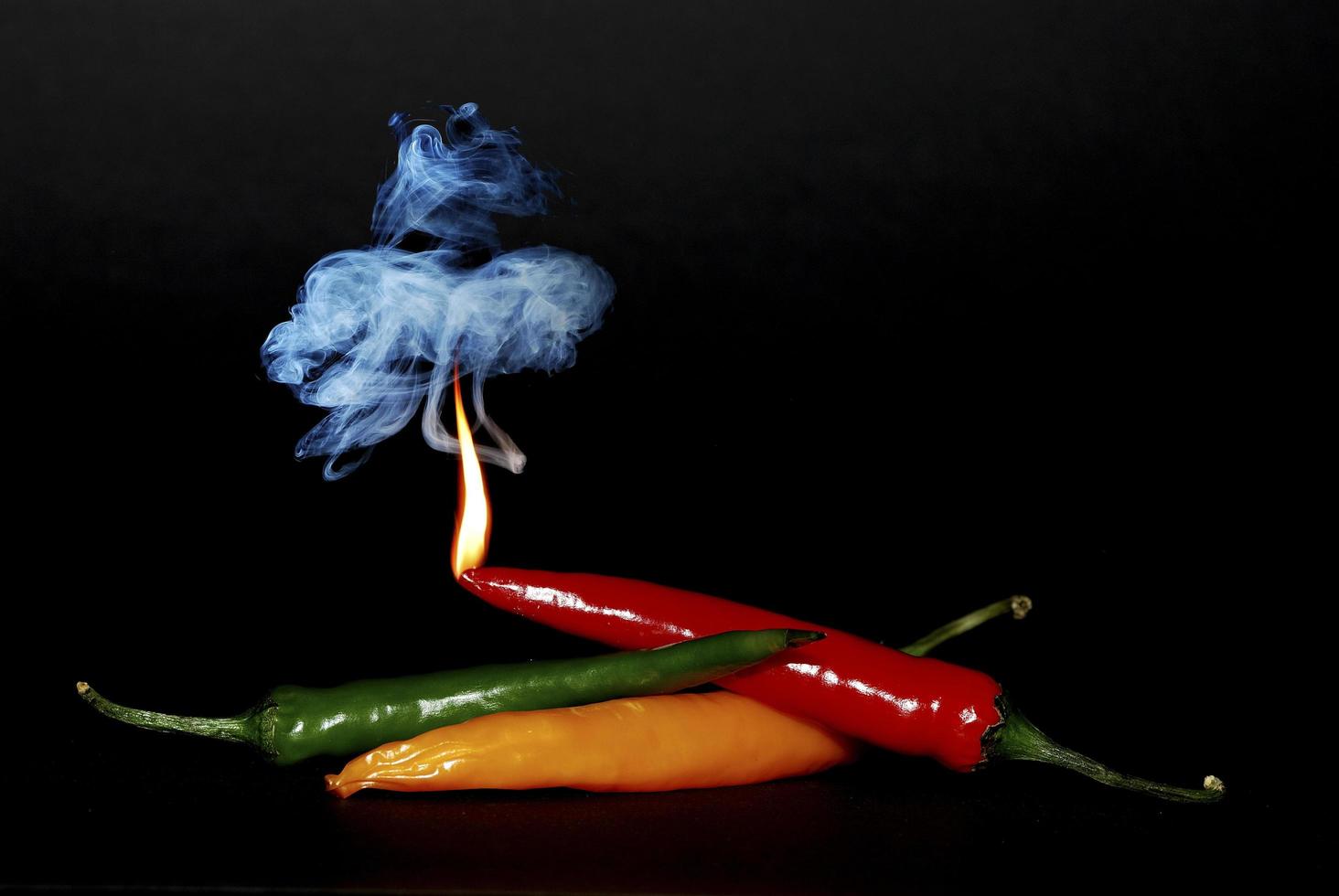 pepper with flame and smoke on black photo