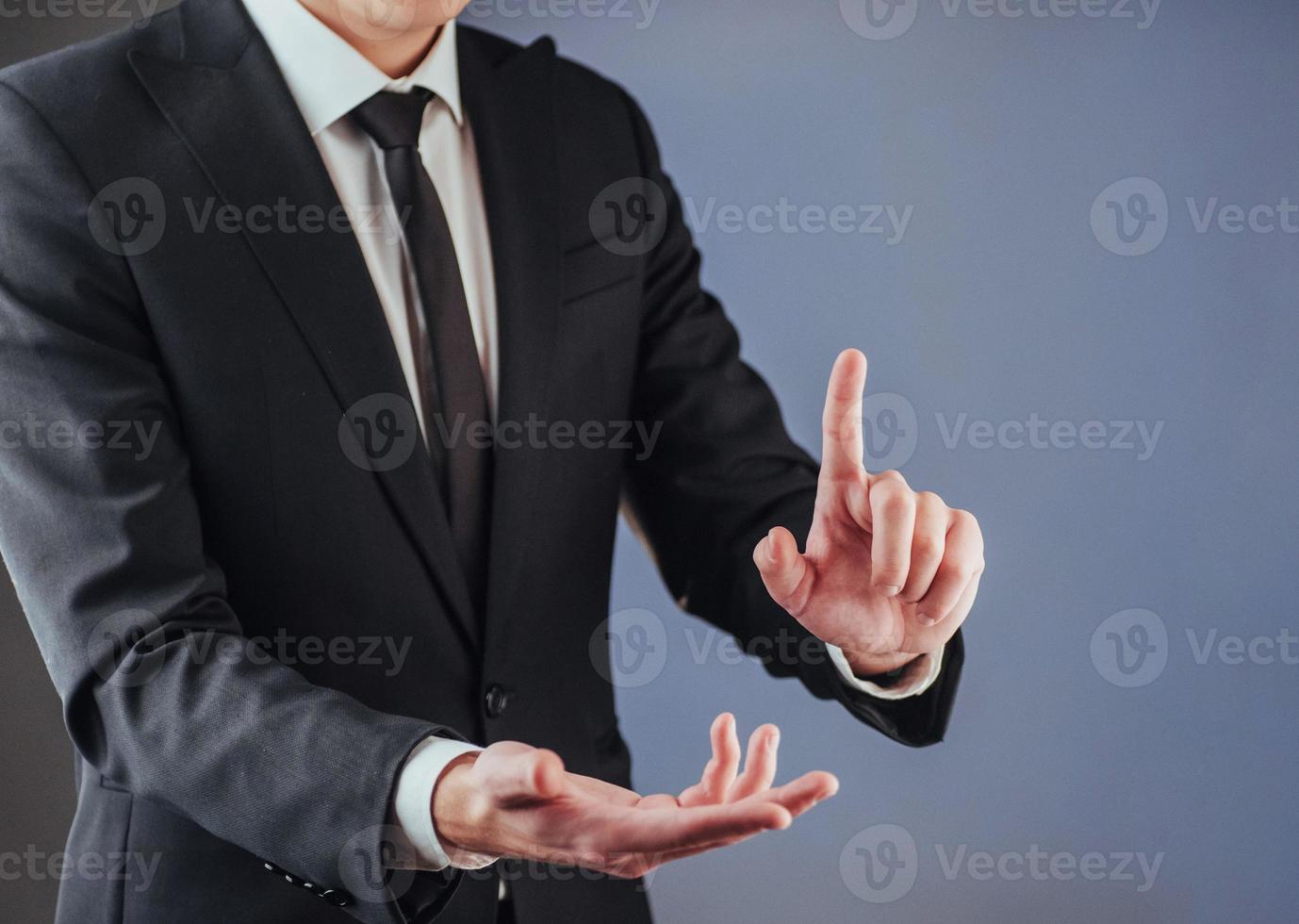 Businessman hand pointing on empty space on black background photo