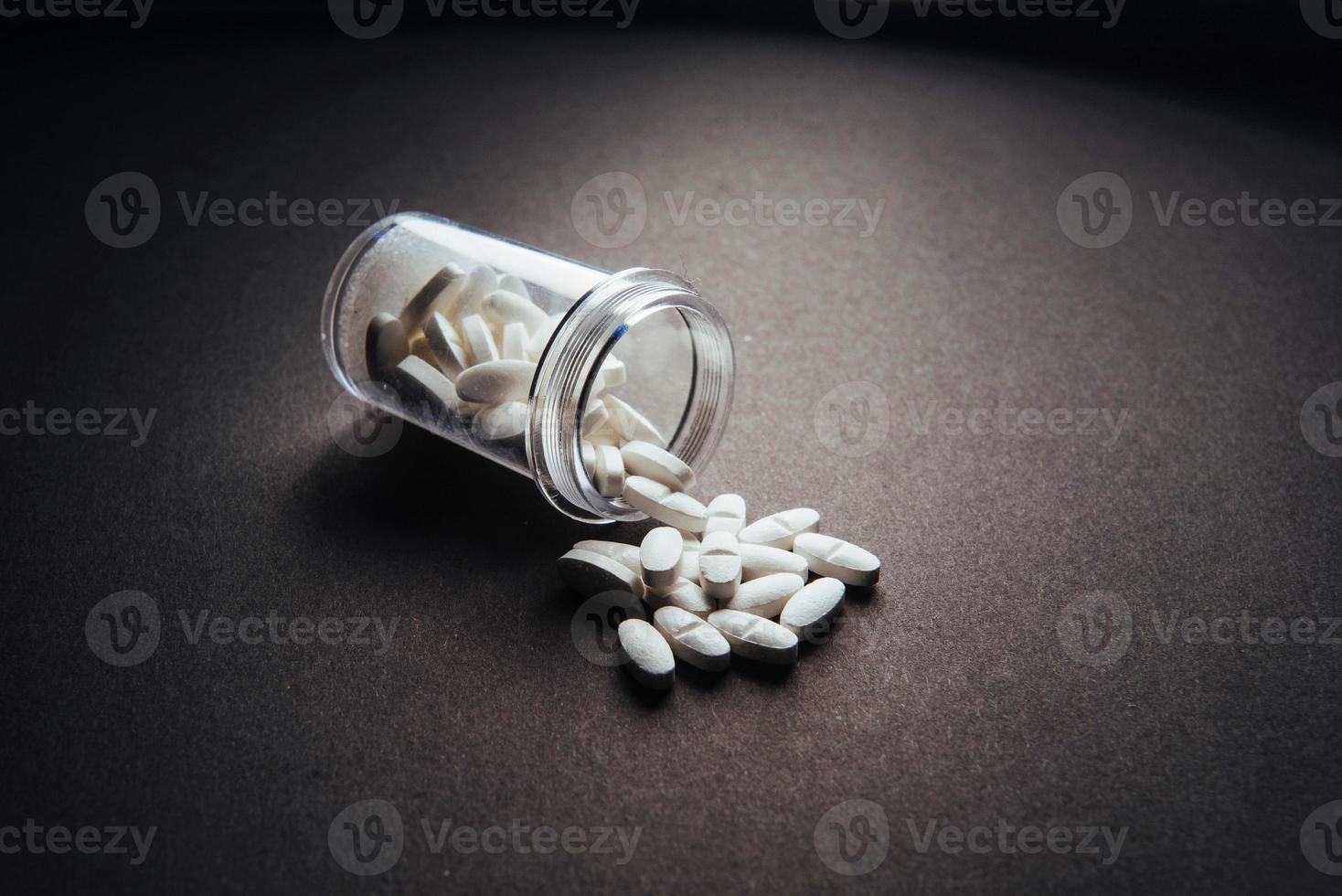 Medical white tablets or supplements for the treatment and health care on a black background photo