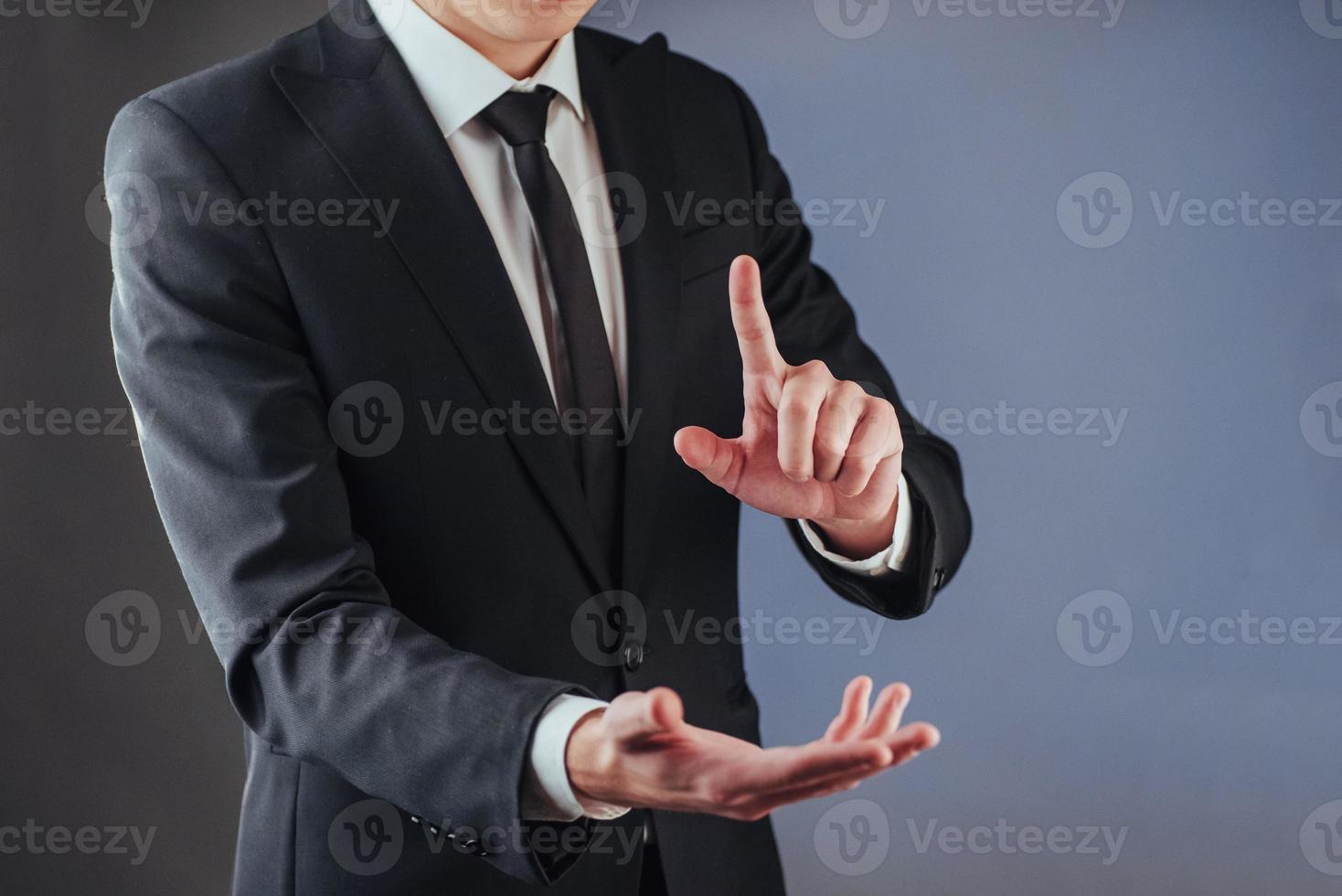 Businessman hand pointing on empty space on black background photo