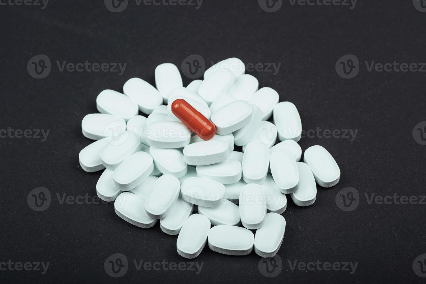 Medical white tablets or supplements for the treatment and health care on a black background photo