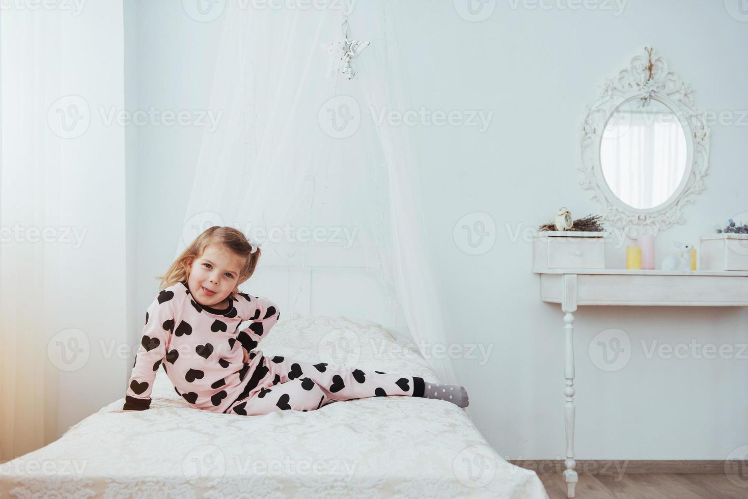 Child in soft warm pajama playing in bed photo