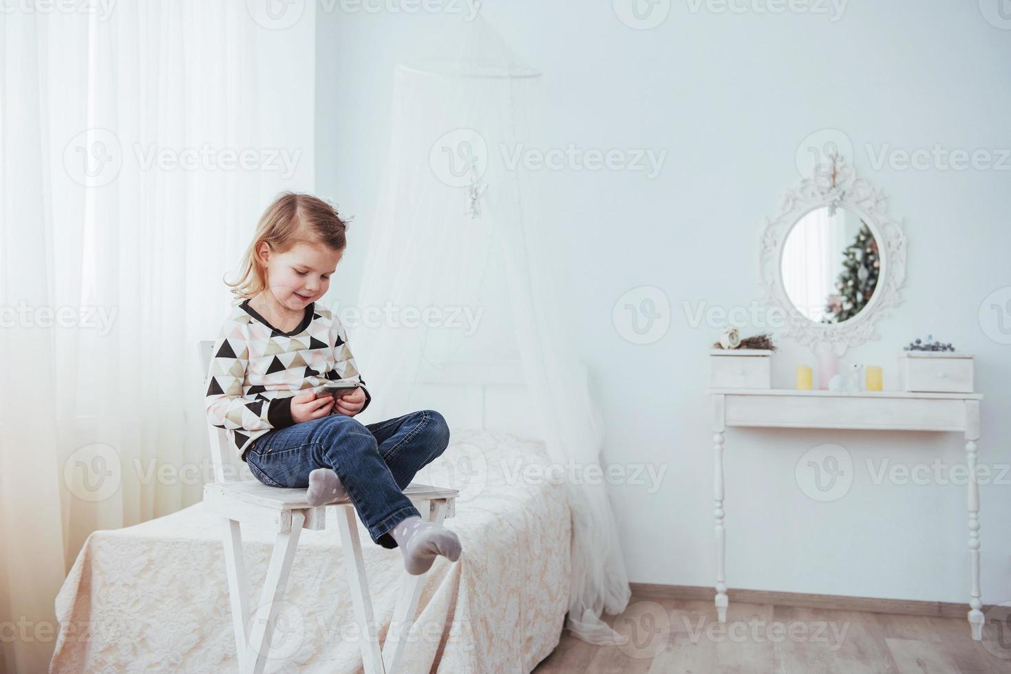 Child in soft warm pajama playing in bed photo