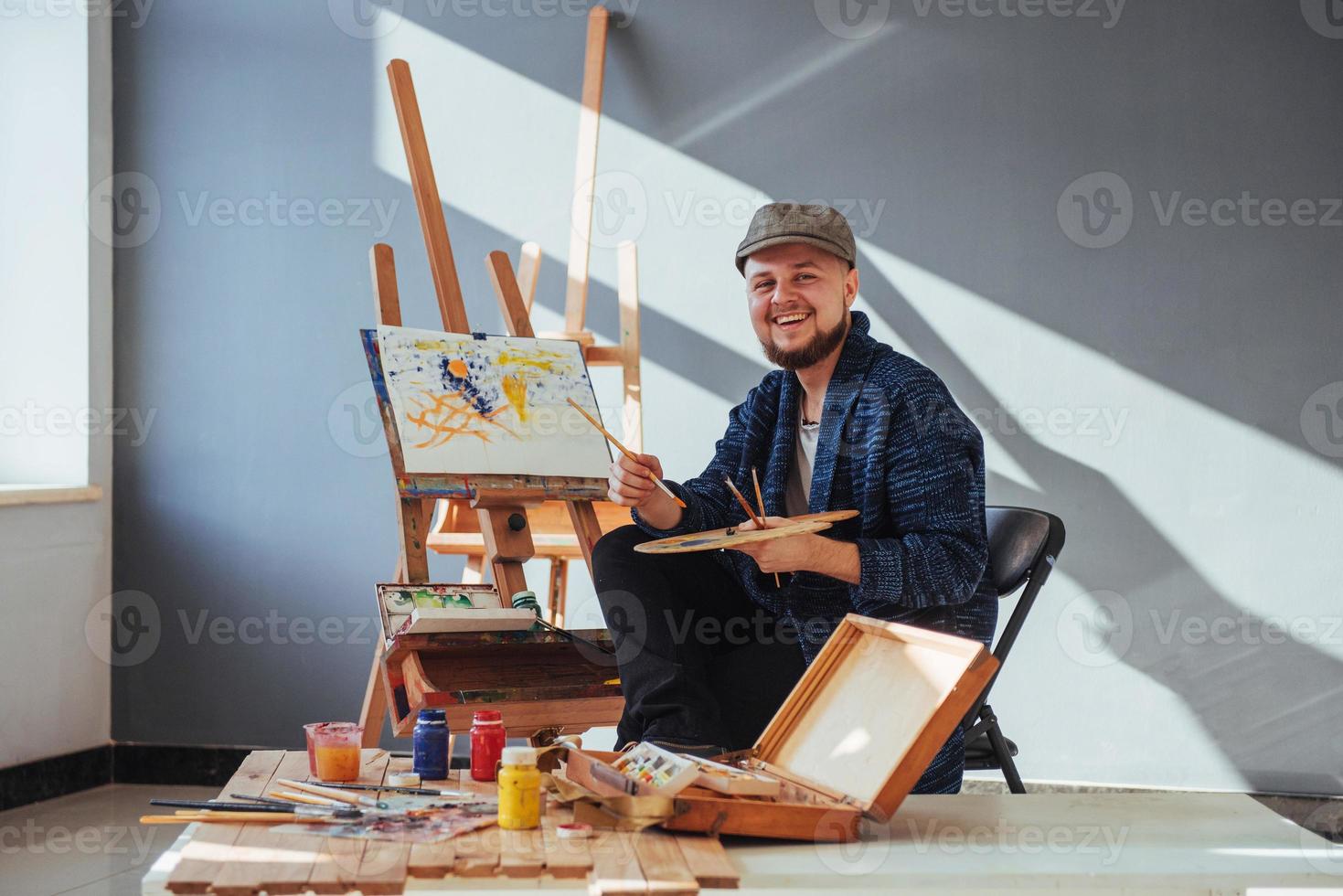 Designed by artist man finishing his masterpiece holds a brush in hand. photo