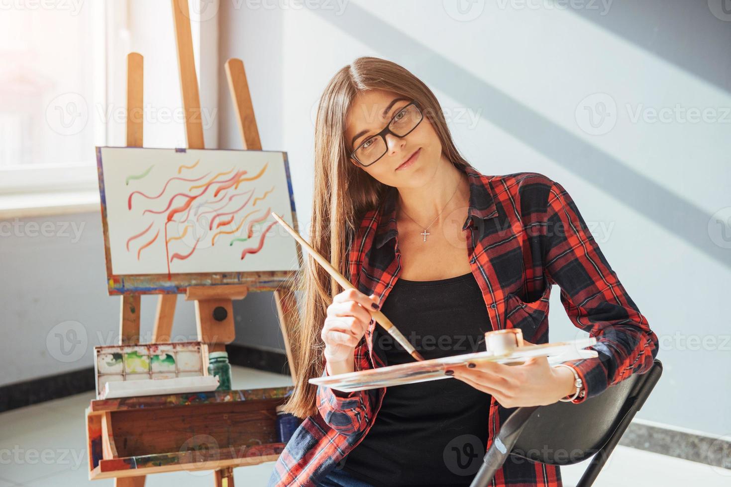 Pretty Pretty Girl artist paints on canvas painting on the easel. photo