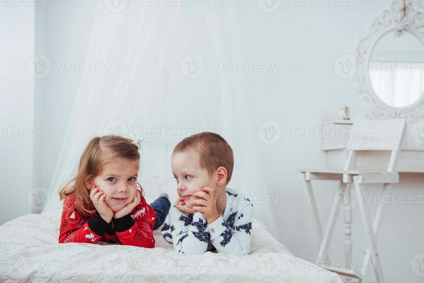 Child in soft warm pajama playing in bed photo