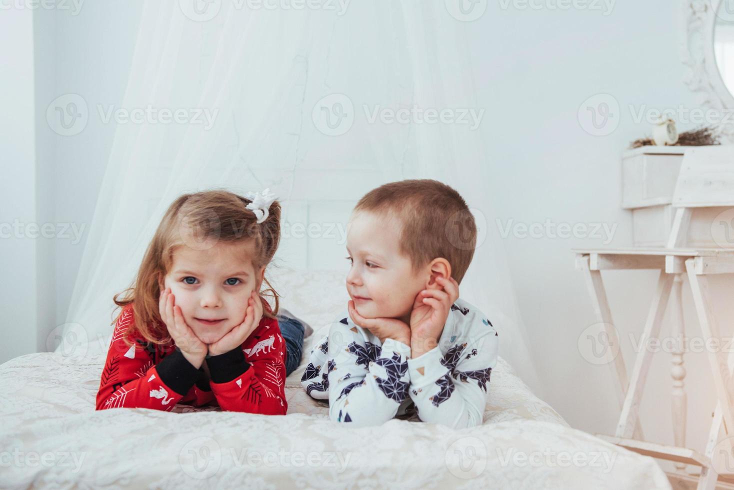 Child in soft warm pajama playing in bed photo