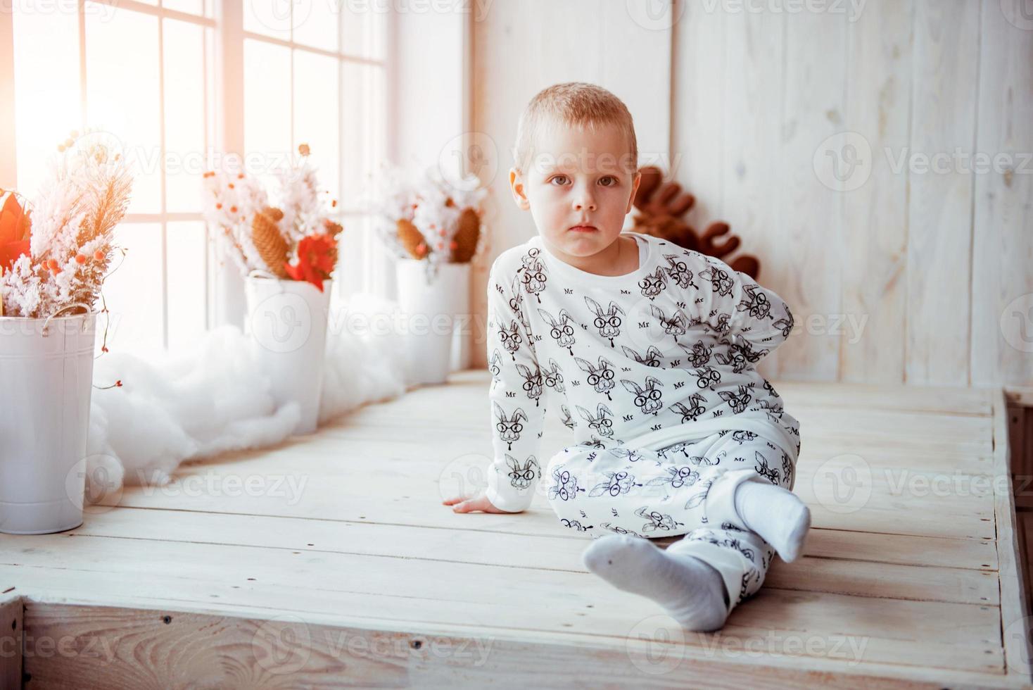 Child in soft warm pajama playing in bed photo