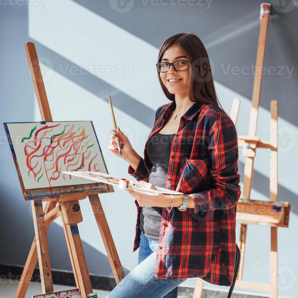 Pretty Pretty Girl artist paints on canvas painting on the easel. photo