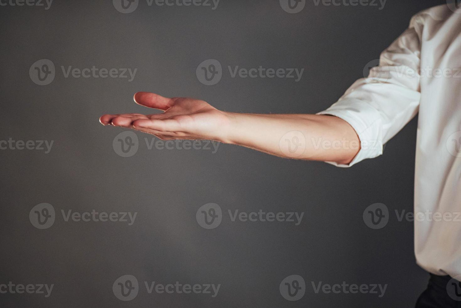 Young businessman showing empty hands, ready to fill with your design photo