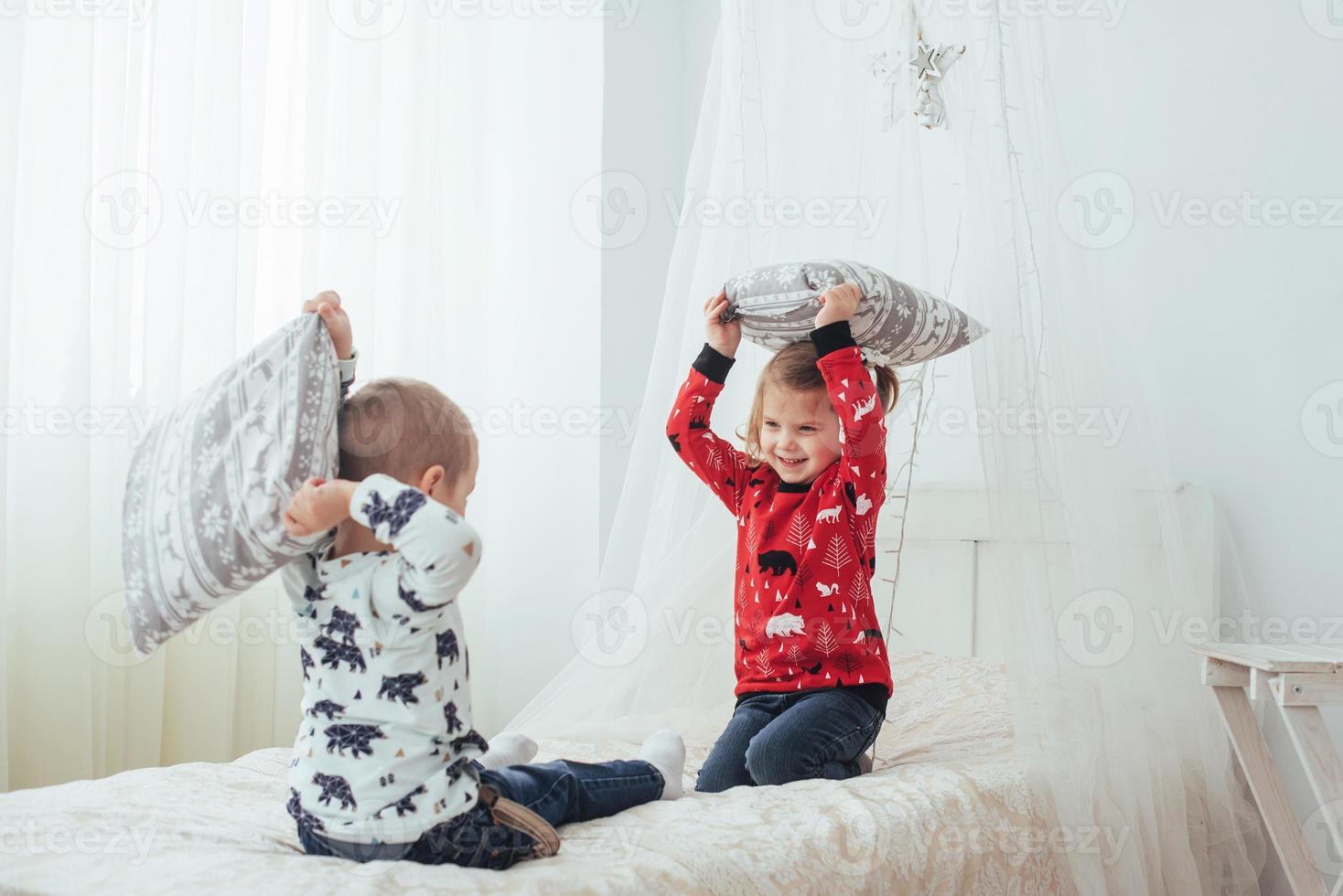Child in soft warm pajama playing in bed photo