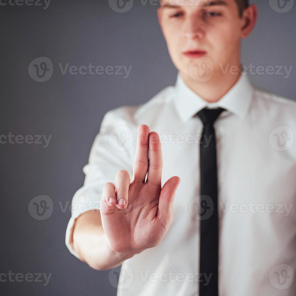 mano de hombre de negocios apuntando al espacio vacío sobre fondo negro foto