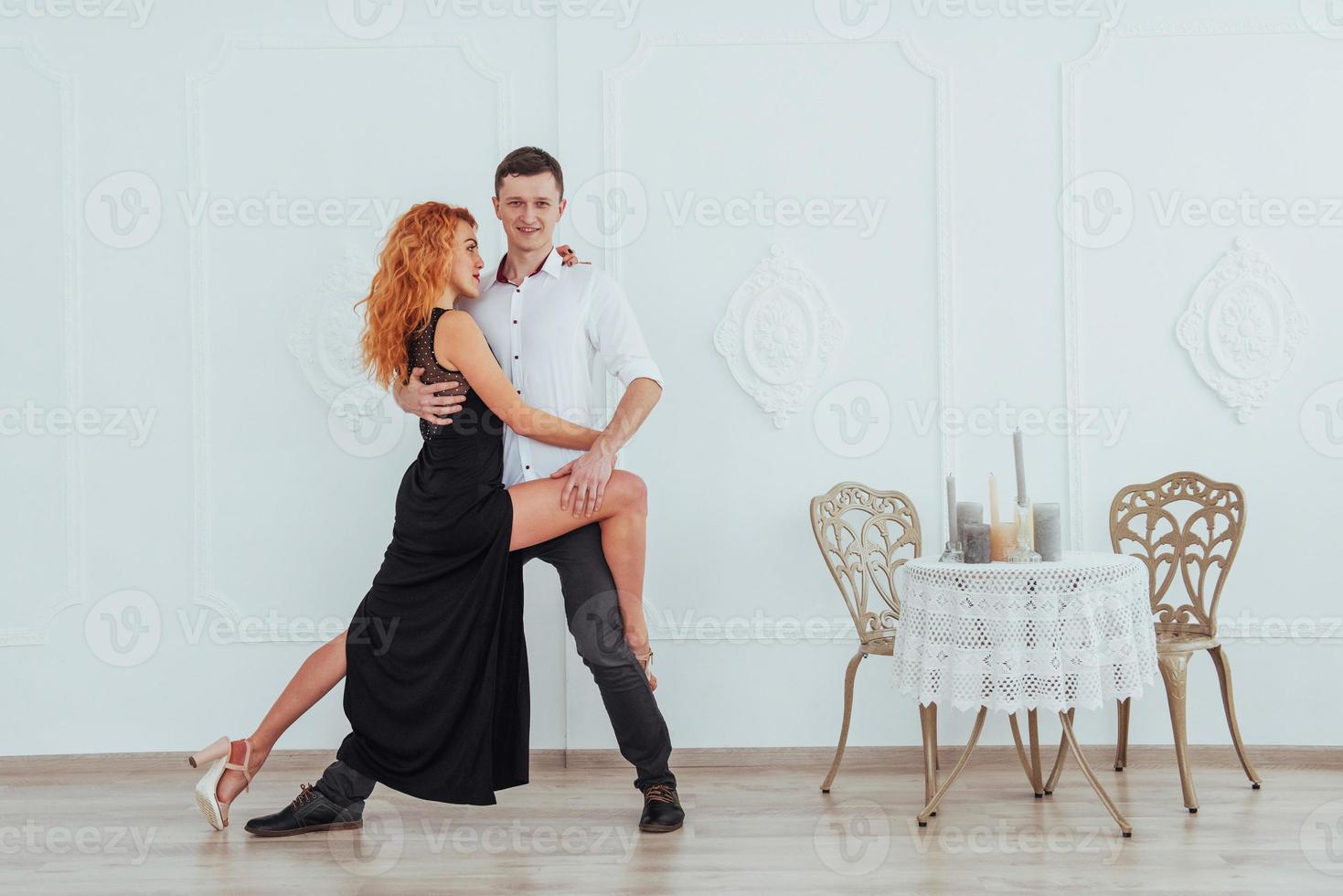 Young beautiful woman in a black dress and a man in white shirt dancing. photo