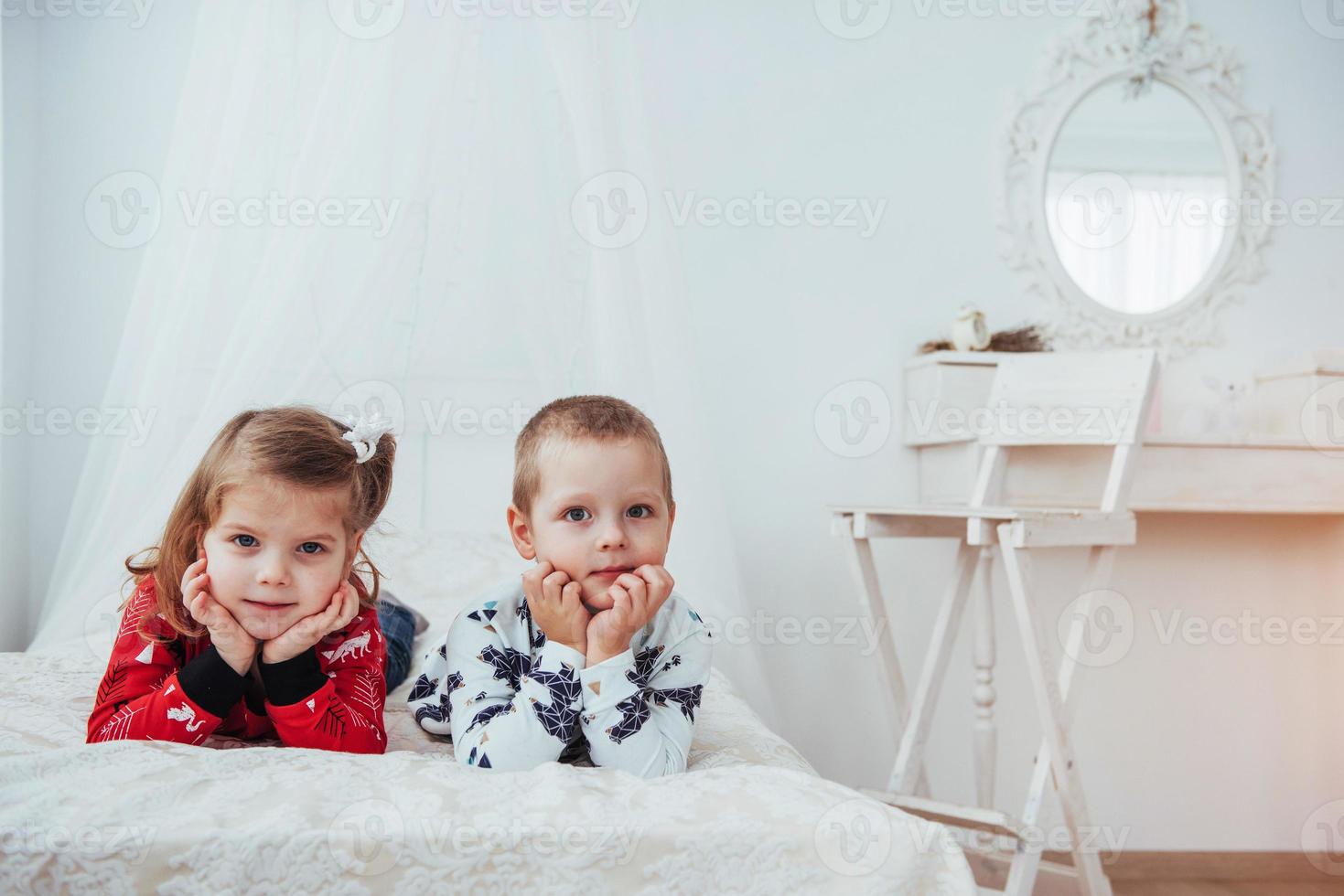 niño en pijama suave y cálido jugando en la cama foto